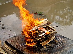 Image 13A Hindu cremation rite in Nepal. The samskara above shows the body wrapped in saffron on a pyre. (from Samskara (rite of passage))
