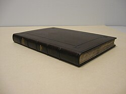A book, bound in dark leather, rests on an off-white surface. There are two pairs of two lines of upper-case gold lettering on the spine, reading "English songs" and "Drexel 4041", and a tooled border on the front cover.