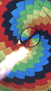 The view from the basket while looking up as a the air is heated in a hot air balloon.