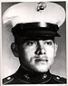 A black and white headshot of Jiminez wearing his military dress blue uniform with hat. He is looking slightly to the right.