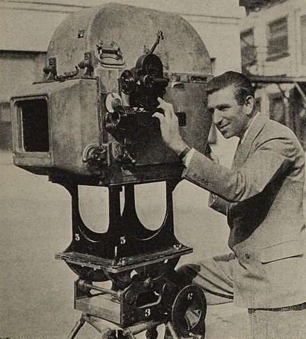 Arnold with his Filmo 16mm camera mounted next to his 35mm film camera, which is housed in his "bungalow" invention