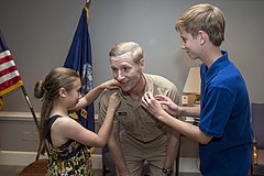 Rear Adm. Joseph Aucoin's children pin on his new rank of vice admiral, May 20, 2013.