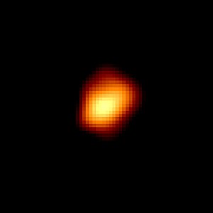 Grainy irregular shaped yellow spot with red rim on a black background