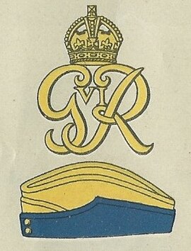 Badge with the royal cypher of George VI and service cap as worn at the outbreak of the Second World War