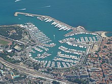 high-altitude view of a port, displaying many parked white boats
