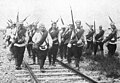 Russian soldiers marching along a railway line. Summer 1914