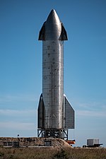 Photograph of a spacecraft with a pair of steel flaps on top and bottom