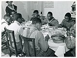 The Negro tenants and neighbors eating dinner after the whit... (3109741227).jpg