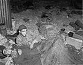 Zwei Häftlinge im Stroh umgeben von Leichen