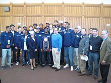 UConn players and coaches, joined by Connecticut Governor Dannel Malloy and Lieutenant Governor Nancy Wyman, pose with the 2011 championship trophy. UConn Men's Basketball 2011 Championship Parade (5630693895).jpg