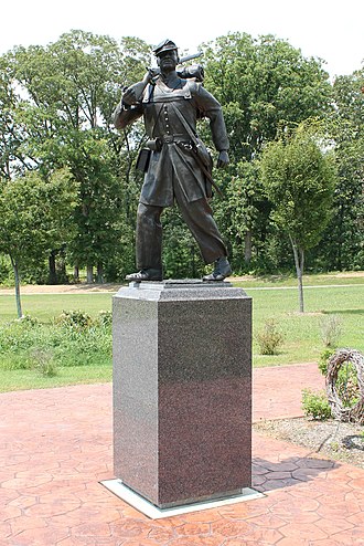 This statue is the centerpiece of the memorial. It shows a USCT soldier in full battle dress, as he would look marching between engagements.
The service of USCT soldiers and sailors was vital to the success of Union forces in the war and would ultimately contribute to the liberation of all enslaved peoples of St. Mary's County and the United States as a whole. It would also lead to the preservation of the Union and the extension of its founding principles to all of its citizens.Photo by Potomac Sun Photography United States Colored Troops Memorial Statue in Lexington Park, Maryland, front view..jpg