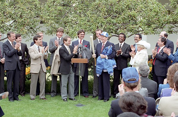 Manager Dick Howser (to left of podium) presents President Ronald Reagan with a Royals jacket, hat, and bat at the White House.