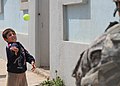 A U.S. Soldier from 214th Military Police (MP) Company, plays catch with a local boy in the northern town of Al Koosh, Iraq, May 3, 2011 110503-A-RH393-305.jpg