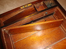 A hidden compartment at the back of a lap desk, with two small drawers concealed beneath the pen and inkwell compartments Antique lap desk with hidden compartment.JPG