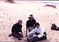 Archaeologists Glynn Isaac, Charles Keller and Maxine Kleindienst doing a surface collection of artifacts in the Sahara Desert in Mauritania 1967 (445057394).jpg