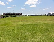 A large portion of the stadium's site is now occupied by an empty field, pictured in 2012. Choctaw Stadium and AT&T Stadium are visible in the background. Arlington Stadium site 2012.JPG