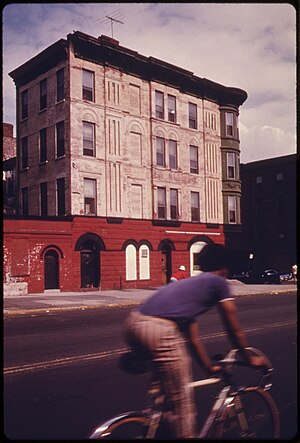 BICYCLIST PASSES AN EXAMPLE OF BROOKLYN ARCHITECTURE ON VANDERBILT AVENUE IN NEW YORK CITY. BROOKLYN REMAINS ONE OF... - NARA - 555894.jpg