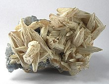 Spiky calcite scalenohedra with a coating of whitish benstonite on a layer of teal-colored fluorite Benstonite-Calcite-Fluorite-154901.jpg