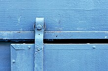 Some sliding doors run on a wall-mounted rail, like this one Blue Sliding Door (Closeup).jpg