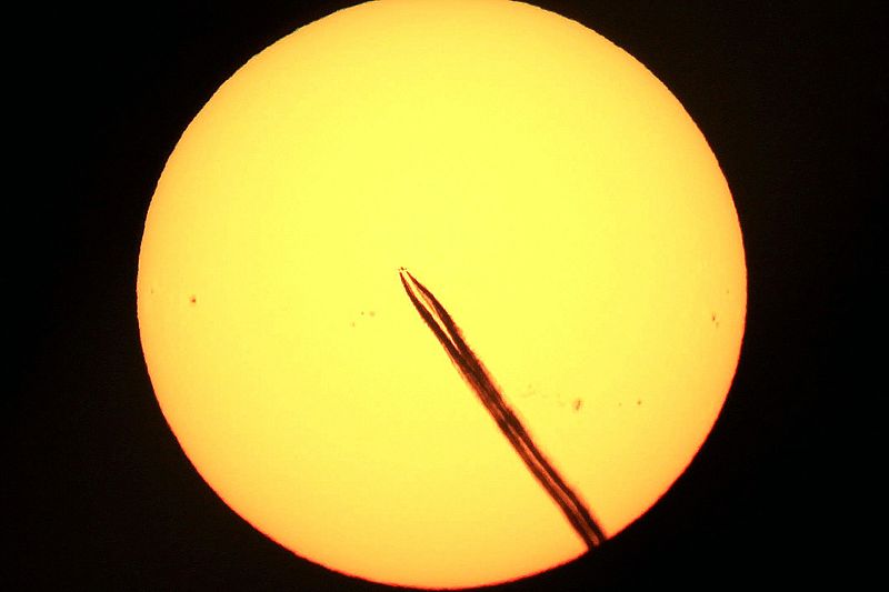 File:Distant plane in front of the sun (11762622124).jpg