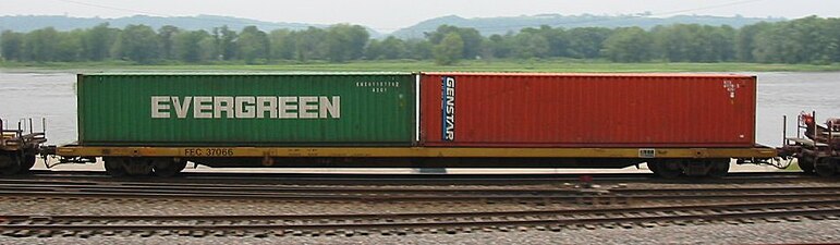 A Florida East Coast Railway flatcar carries two shipping containers as it passes through Glen Haven, Wisconsin.