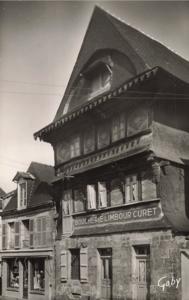 La maison est un commerce ayant pour enseigne Boucherie Limbour-Curet vers 1950.