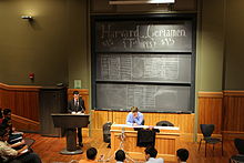 Scoreboard and host at the Harvard Certamen quiz bowl Harvard Certamen moderation.JPG