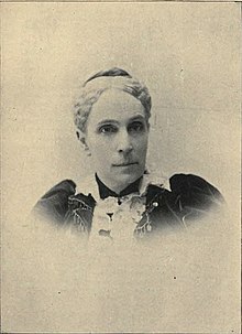 Portrait photograph of middle-aged woman with gray hair.