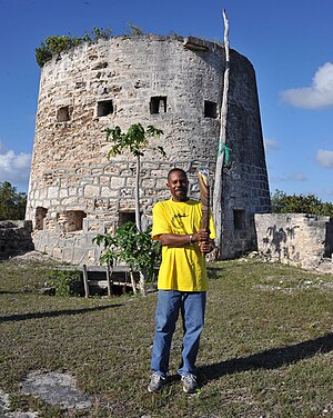 Honourable Trevor Walker, Parliamentary Representative for Barbuda holding the Queen's Baton 2010 Delhi in front of the Martinello Tower, Barbuda.jpg