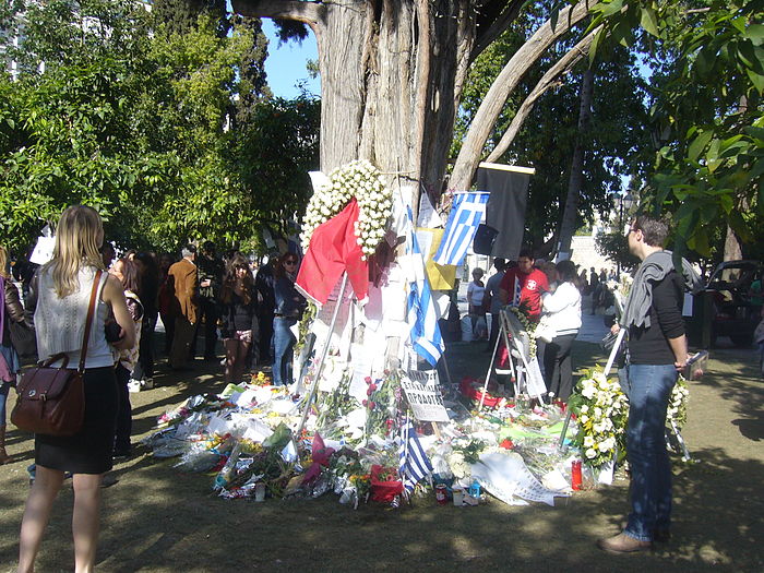 The tree where Dimitris Christoulas committed suicide, Plenty of notes, wreaths and Greek flags (Syntagma Square Sunday April 8, 2012) Location of suicide of Dimitris Christoul.JPG