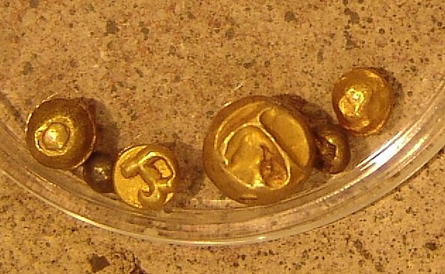 A collection of gold Piloncitos stamped with the Baybayin character for "Ma" possibly representing the nation of Ma-i.