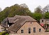 Boerderij onder rieten wolfdak. Vensters met negen-, twaalf- en twintigruitsschuiframen. Inrijdeuren in de linker zijgevel van de stal. Boven de inrijdeuren hooiluiken onder zadeldakje