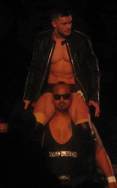 Prince Devitt, the original de facto leader of Bullet Club, on the shoulders of Bad Luck Fale