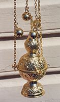 An Eastern Orthodox censer, gold with four chains and bells