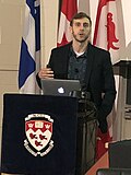 Executive Director Ryan Armstrong speaking at an event hosted by the Office for Science and Society in 2019. Ryan Armstrong OSS 20.jpg