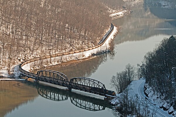 A long CSX coal train of empty hoppers crosses the New River as seen from Hawks Nest State Park