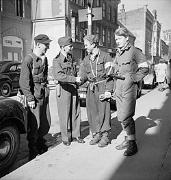 Två beväpnade motståndsmän i Oslo hälsar på en RAF-major när de brittiska styrkorna anländer den 11 maj 1945.