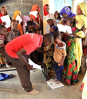 Kenyan health worker weighs a young Kenyan boy to determine if he is malnourished US Navy 110829-A-ZZ999-361 A Kenyan health worker weighs a young Kenyan boy to determine if he is malnourished during a Medical Civic Action Progra.jpg