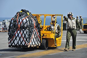 US Navy 120116-N-KD852-039 Marines from Combat Cargo assigned to 11th Marine Expeditionary Unit (11th MEU) move supplies across the flight deck abo.jpg