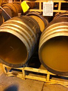 Winemakers can encourage diacetyl production by keeping the wine sur lie in the barrel. The barrel on the right has recently been stirred with a batonage tool. Unstirred and stirred barrels of chardonnay on lees.jpg
