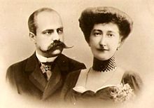Photo en noir et blanc en buste de Victor Napoléon, en costume, le crâne dégarni, portant une moustache imposante regardant Clémentine, légèrement souriante, les cheveux relevés et arborant un haut collier ras-du-cou.