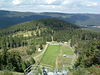 Blick über den Auslauf der Wurmbergschanze zum Großen Winterberg; der baumlose Streifen links davon zeigt den Verlauf der früheren innerdeutschen Grenze an; hinten rechts Ausläufer von Schierke