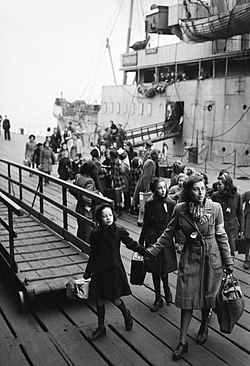 A Dutch school teacher leads a group of refugee children just disembarked from a ship at Tilbury Docks in Essex during 1945. D24064.jpg