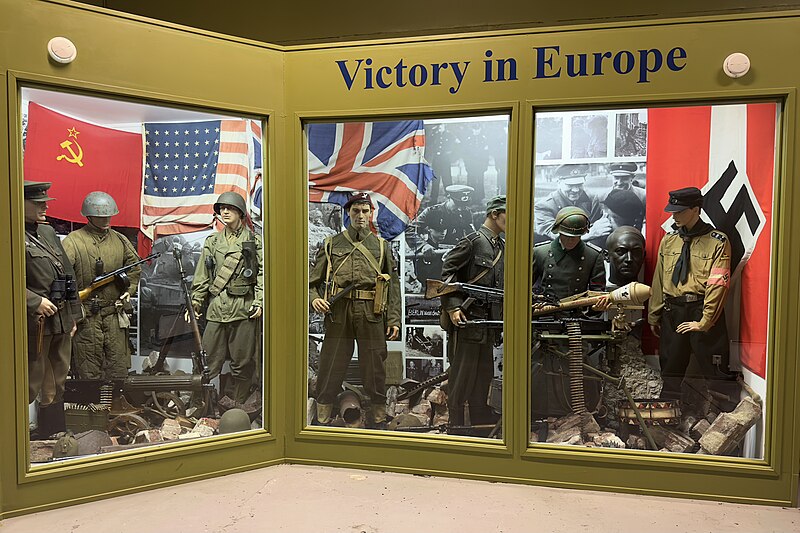 File:Arquebus Krigshistorisk Museum Norway. WW2 Allied Victory in Europe display. Uniforms weapons equipment USSR Red Army officer private US private British paratrooper battle dress German Waffen-SS Volkssturm Hitlerjugend flags photos B.jpg
