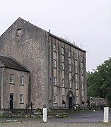 Photo un bâtiment de quatre étages massif, aux murs gris percés de petites fenêtres carrées