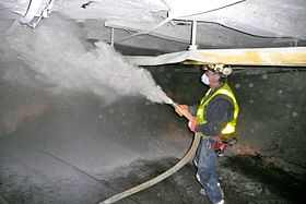 Coal miner spraying rock dust to mitigate coal dust in a mine. Coal miner spraying rock dust.jpg