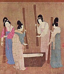 A painted image of four Chinese women wearing colorful silk robes, their hair tied up into buns, standing around a small wooden block with silk laid on top while holding large whisks which they use to beat the silk