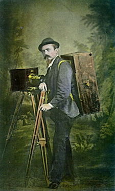 Jindřich Eckert s vybavením fotografa krajin (autoportrét), kolorovaná vizitka, kolem 1870