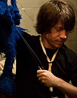 Eric Jacobson (2015), pictured here performing Grover Eric Jacobson (2682319455).jpg