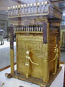 Vue d'ensemble du coffre canope le plus externe de Toutankhamon.  A droite se trouve la statuette de Selkis, avec un scorpion sur la tête ;  de dos, la tête surmontée d'un trône, est Isis.  Musée égyptien du Caire.